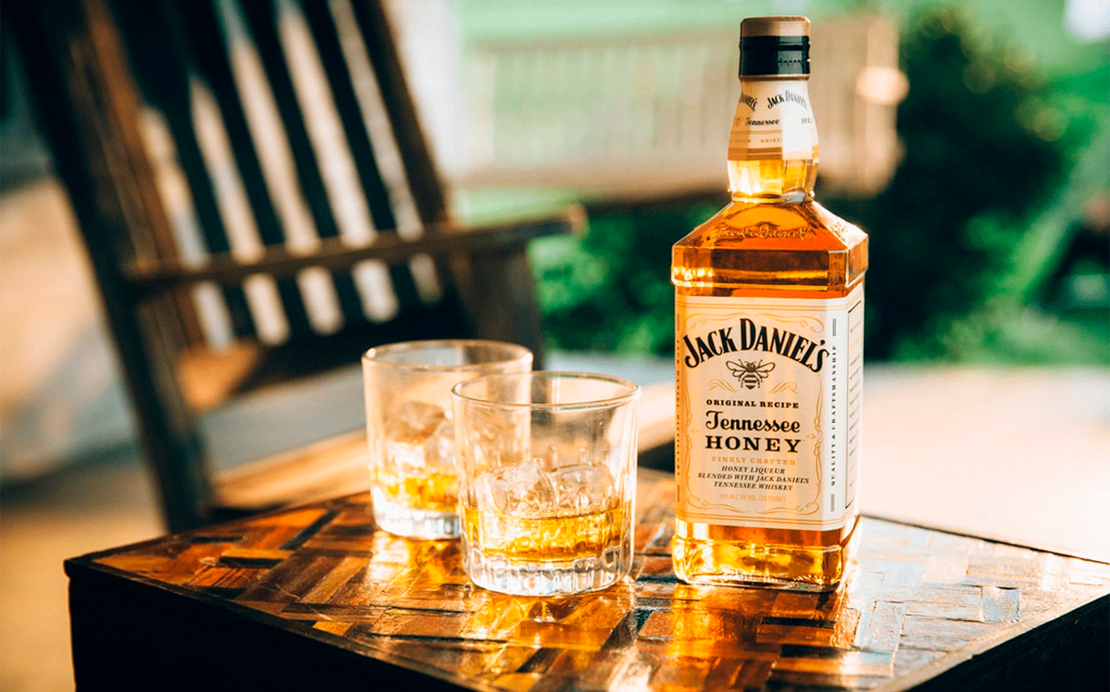 A bottle of Jack Daniel's Honey and two glasses on a table